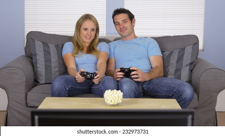 Couple In Matching Clothes Playing Video Games