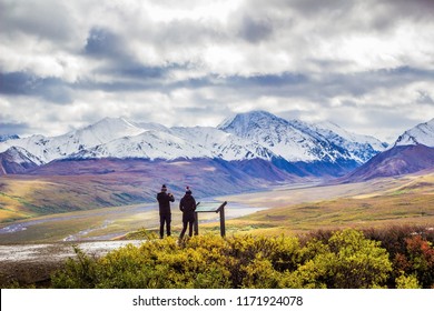 Couple In Matching Outfits Takes Photographs Of Mount Denali In Alaska