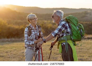 Couple Of Mature Hikers Talking At The Field At The End Of Day