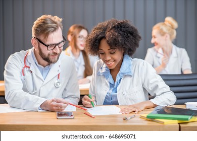 Couple Of Medical Students Sitting Together And Studying During The Lesson In The Classroom