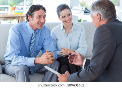 Couple In Meeting With A Financial Adviser In Living Room