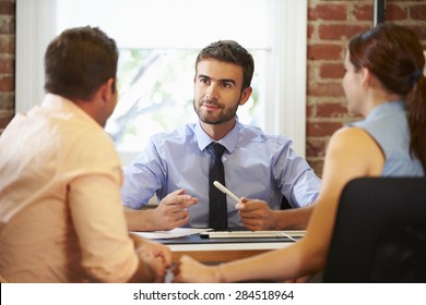 Couple Meeting With Financial Advisor In Office