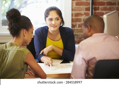 Couple Meeting With Financial Advisor In Office