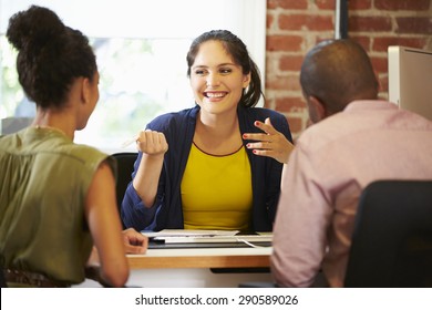 Couple Meeting With Financial Advisor In Office