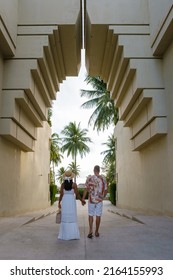 Couple Men And Woman Walking At An Old Gate During Vacation At An Luxury Resort In Thailand