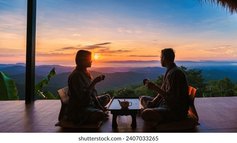 a couple of men and women drinking tea at a Japanese style homestay on vacation in Northern Thailand, staying at a homestay cabin hut in the mountains of Chiang Rai Doi Chang - Powered by Shutterstock