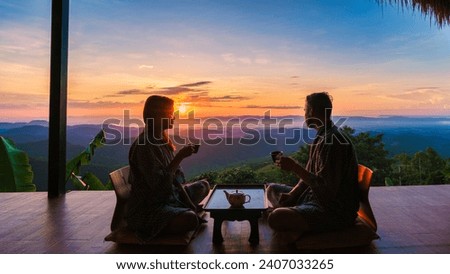 a couple of men and women drinking tea at a Japanese style homestay on vacation in Northern Thailand, staying at a homestay cabin hut in the mountains of Chiang Rai Doi Chang