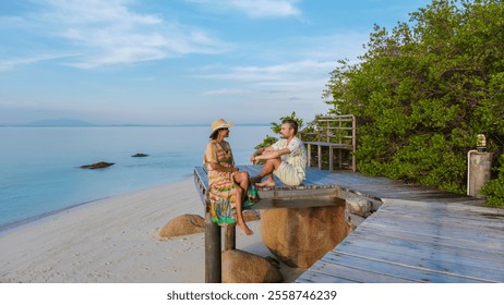 A couple of men and women enjoy a serene afternoon on the sandy beach of Koh Munnork Island in Rayong Thailand. The gentle waves and soft breeze create a perfect escape for relaxation and connection. - Powered by Shutterstock