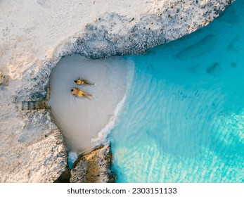 a couple of men and women on the beach of Tres Trap Aruba Caribbean Island. Tres Trapi Bay is popular with locals for snorkeling and diving in the turqouse colored ocean - Powered by Shutterstock