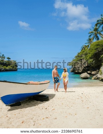 A couple of men and women in swimshorts and bikinis at Playa Lagun Beach Cliff Curacao,