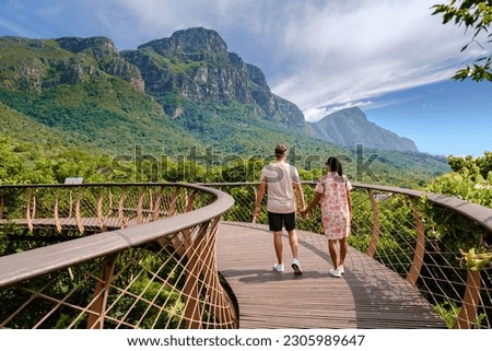 couple of men and women walking at the boomslang walkway in the Kirstenbosch botanical garden in Cape Town, Canopy bridge at Kirstenbosch Gardens in Cape Town, built above lush foliage South Africa