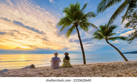 Couple men and women watching sunset on the beach, Bang Tao Beach during sunset in Phuket Thailand, and palm trees during sunset on the beach.  - Powered by Shutterstock