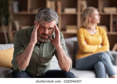 Couple Misunderstanding. Depressed Middle Aged Man Sitting Upset After Argue With Wife, Pensive Male Touching Temples, Tired Of Domestic Conflicts With Spouse, Suffering Mid-Life Crisis - Powered by Shutterstock