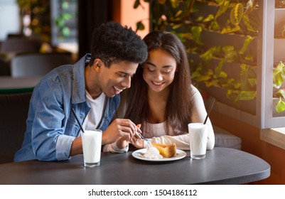 Couple Of Mixed Race Teenagers Eating Cheesecake With Ice Cream At Cafe And Smiling, Empty Space