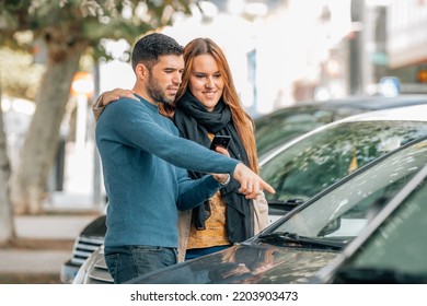 Couple With Mobile Phone Looking At Cars To Buy, Buy Car