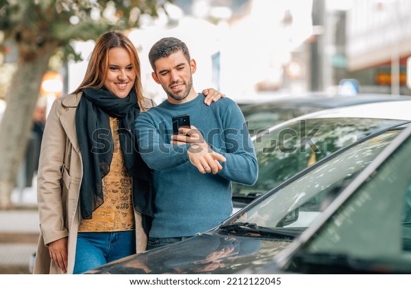 couple\
with mobile phone looking at cars to buy, buy\
car
