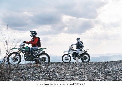 Couple Of Motorcyclists Traveling Offroad, Standing On Mountain Top, Enjoying View 