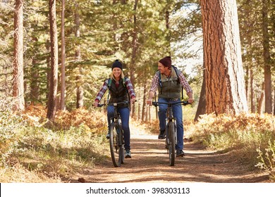 Couple Mountain Biking Through Forest, California