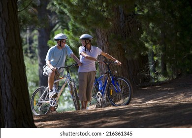 Couple Mountain Biking In Woods