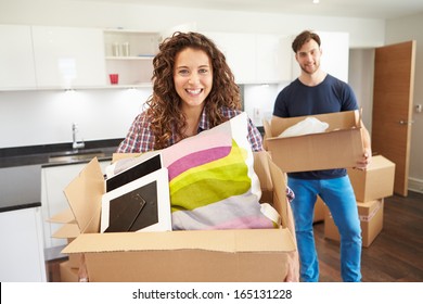 Couple Moving Into New Home And Unpacking Boxes