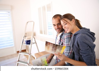 Couple in new house choosing color for walls - Powered by Shutterstock