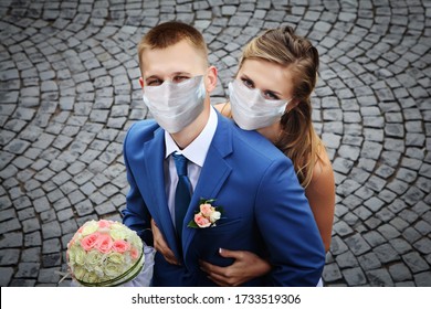 Couple of newlyweds walks in medical facial disposable masks for respiratory protection during the coronavirus pandemic and home isolation, wedding season summer 2020. - Powered by Shutterstock