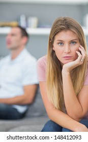 Couple Not Talking After A Dispute On The Couch With Woman Looking At Camera In Living Room At Home