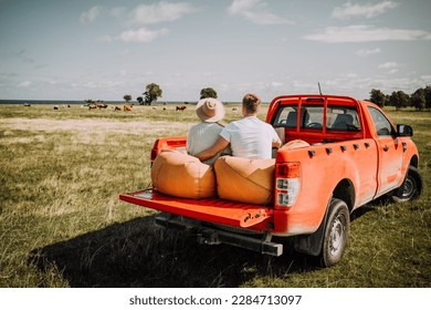 Couple Observing Animals On Island On A Red Pickup Truck In Summer - Powered by Shutterstock