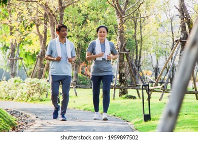 A Couple Of Older Asian Men And Women Wear Exercise Clothes Before Their Morning Exercises.Men And Women Jogging In The Morning In The Garden.