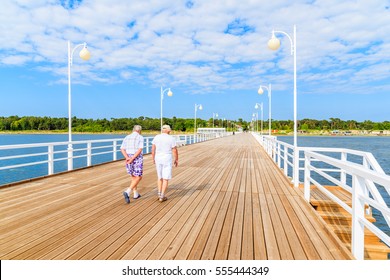 Couple of older men walking on wooden pier in Jurata town on coast of Baltic Sea, Poland - Powered by Shutterstock