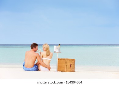 Couple On Beach With Luxury Champagne Picnic