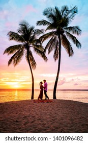 couple on the beach with palm trees watching sunset at the tropical beach of Saint Lucia or St Lucia Caribbean