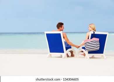 Couple On Beach Relaxing In Chairs