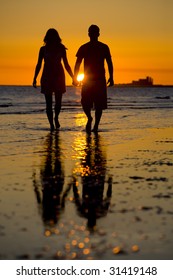 A Couple On The Beach At Sunset