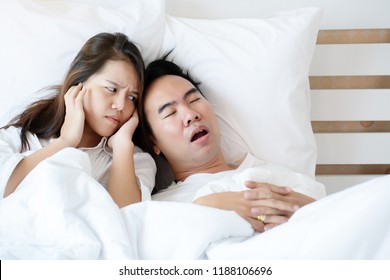 Couple On Bed With White Mattress Man Snoring Loud Makes Women Feel Annoyed. Causes Of Obstructive Sleep Apnea Stroke Chronic Depression Sexual Dysfunction It Can Be A Cause Of Divorce In A Spouse.