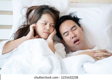 Couple On Bed With White Mattress Man Snoring Loud Makes Women Feel Annoyed. Causes Of Obstructive Sleep Apnea Stroke Chronic Depression Sexual Dysfunction It Can Be A Cause Of Divorce In A Spouse.