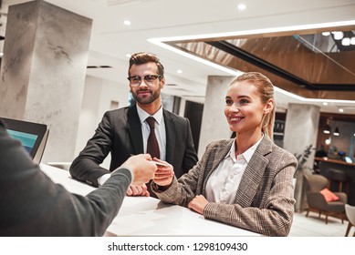 Couple on a business trip doing check-in at the hotel - Powered by Shutterstock