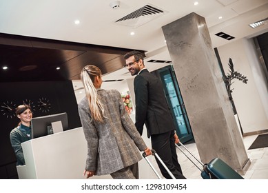 Couple On A Business Trip Doing Check-in At The Hotel