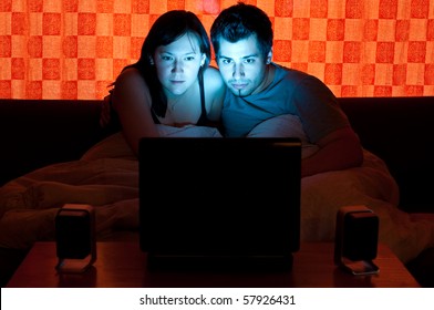 couple on a couch watching a movie on a laptop