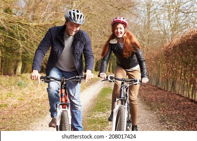 Couple On Cycle Ride In Winter Countryside