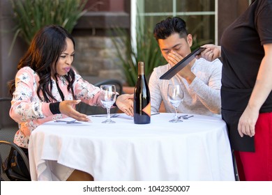 Couple On A Date Angry At A Waitress In An Outdoor Restaurant.  They Are Upset And Dissatisfied With The Customer Service Or The Food In The Cafe.  The Image Depicts The Food And Service Industry. 