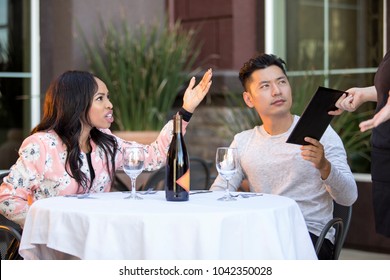 Couple On A Date Angry At A Waitress In An Outdoor Restaurant.  They Are Upset And Dissatisfied With The Customer Service Or The Food In The Cafe.  The Image Depicts The Food And Service Industry. 