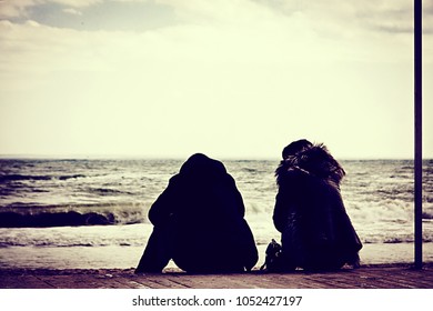 Couple On A Date By The Sea In Winter. Photo In The Style Of Old Film With Blackout.