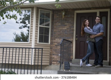 Couple On Front Steps Of New Home