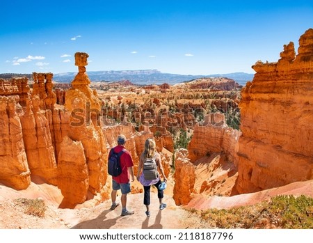 Couple on hiking trip looking at beautiful  mountain landscape,  People relaxing on top of the mountain. Famous Thor's Hammer hoodoo. Bryce Canyon National Park, Utah, USA 商業照片 © 