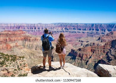 Couple On Hiking Trip. Man Using His Camera. Beautiful Mountain Landscape In Arizona. North Rim, Grand Canyon National Park, Arizona, USA