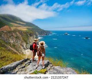 Couple on hiking trip resting on top of the mountain looking at ocean view. People enjoying beautiful coastal scenery. Pacific Ocean, Big Sur, California, USA - Powered by Shutterstock