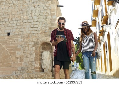 Couple on holiday walk, reading a guidebook, three quarters - Shutterstock ID 562337233