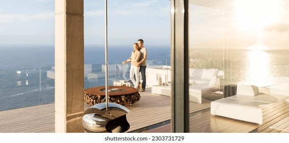 Couple on modern balcony overlooking ocean - Powered by Shutterstock