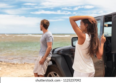 Couple On A Road Trip Travel Holiday In Hawaii Driving Car On Beach. Young People Tourists Enjoying Vacation.